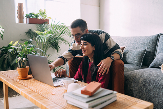 man and woman at home using laptop