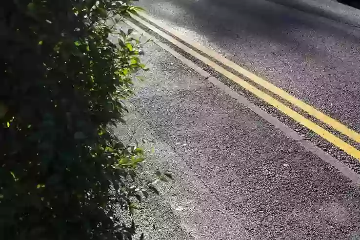 A road with double yellow lines running along the curb, with no parked cars or vans.