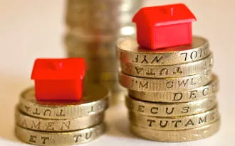 miniature house model on coins stack