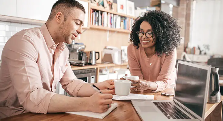 A couple in the kitchen with laptop doing their finances