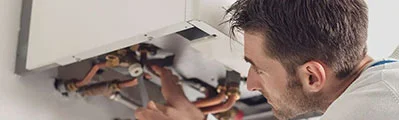 professional engineer repairing a boiler