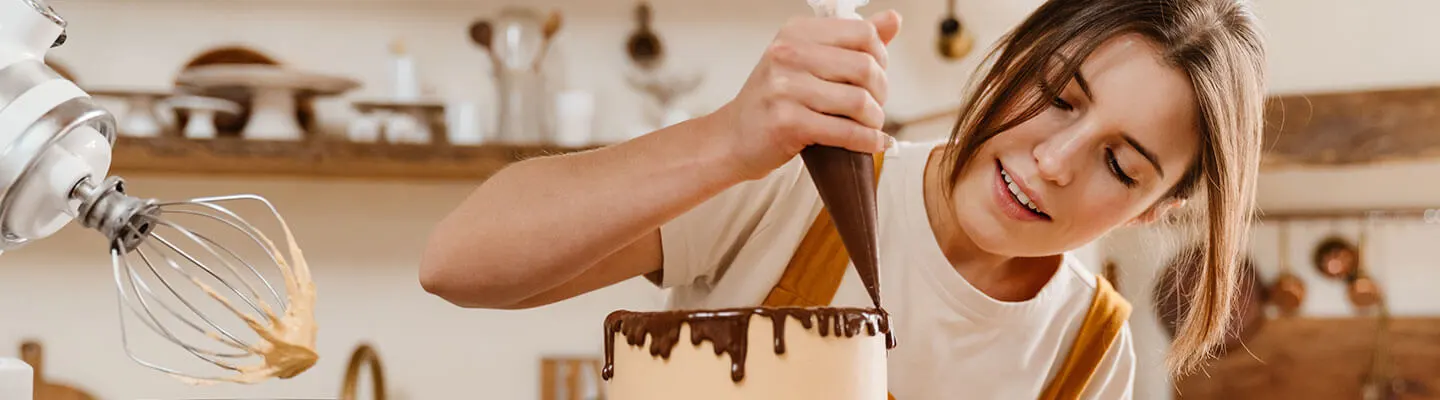 A woman decorating a cake