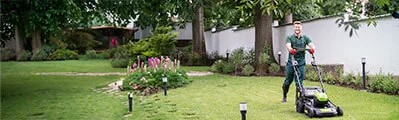 gardener mowing the lawn with a lawn mower